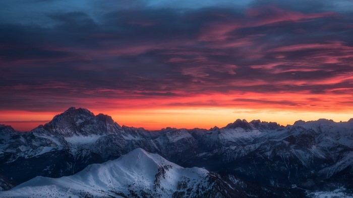 Snowy mountains at sunset with colorful sky