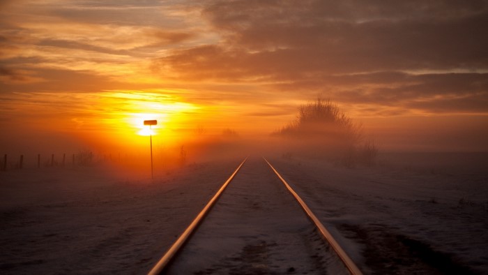 Railway tracks at sunset with fog