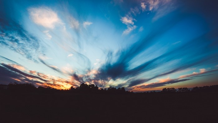 Dramatic sunset sky over silhouetted trees