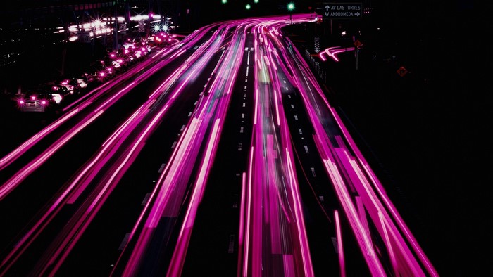 Pink light trails on a highway at night