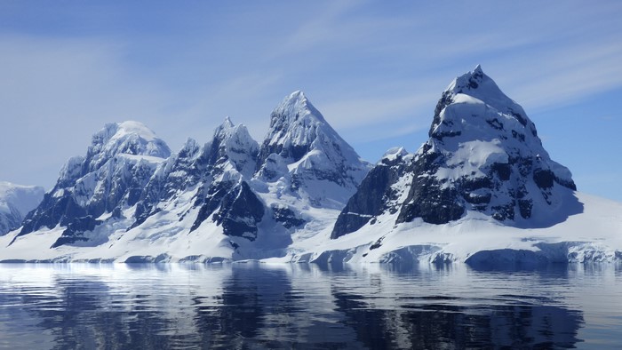 Snow-capped mountains reflected in the sea