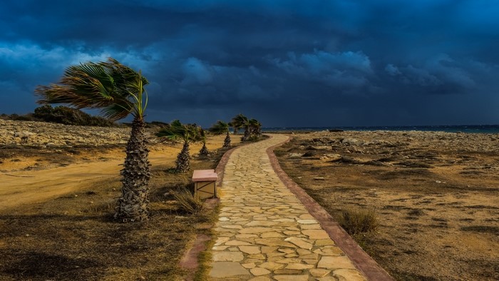 Stone path to the sea under stormy clouds