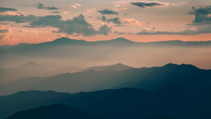 Mountain ranges at sunset with clouds