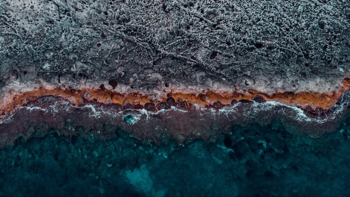 Aerial view of rocky coastline and ocean waves