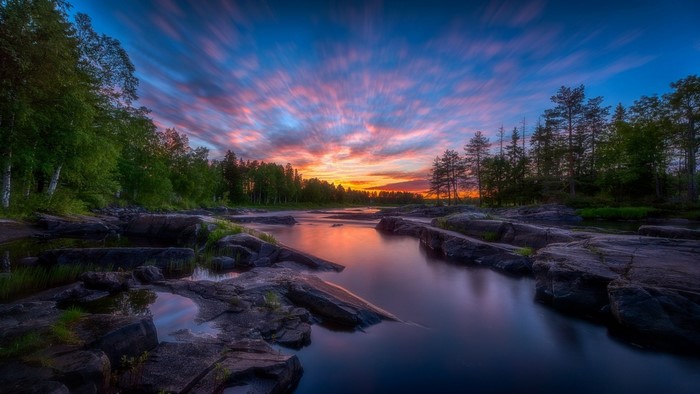 Sunset over a rocky river with trees