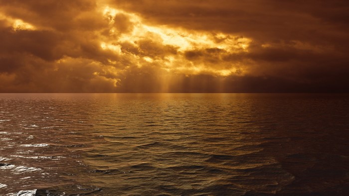 Sunset over the ocean with dramatic clouds