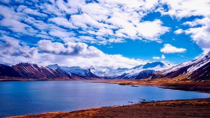 Snowy Mountains and Lake with Blue Sky and Clouds