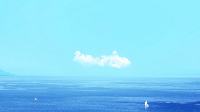 Sailboat on the ocean under a cloudy sky