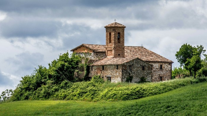 Stone building with bell tower on a hill