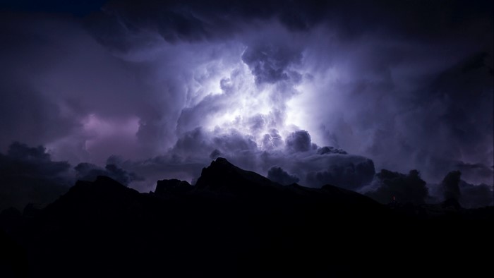 Lightning storm over dark mountains