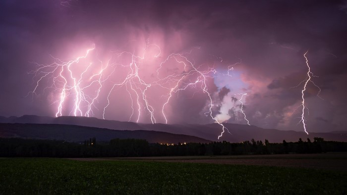 Multiple lightning strikes over mountains during a storm