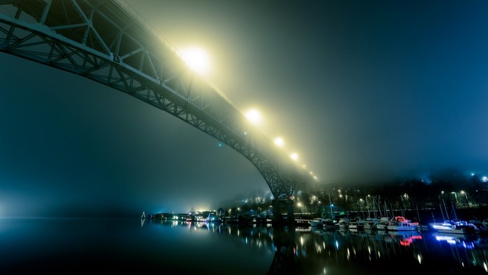 Bridge over water at night with fog