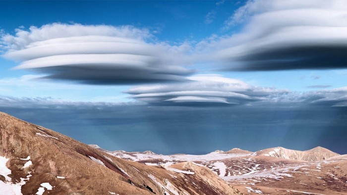 Lenticular clouds over mountains