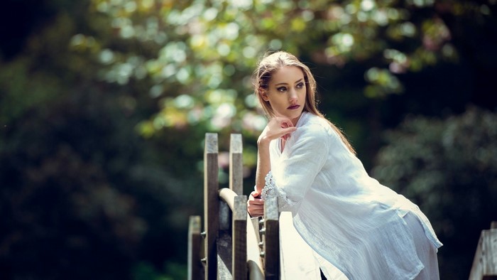 Woman in white dress on a wooden bridge
