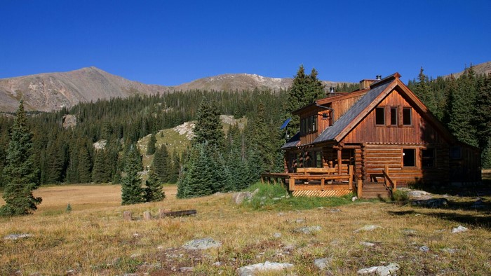 Log cabin in a mountain forest clearing