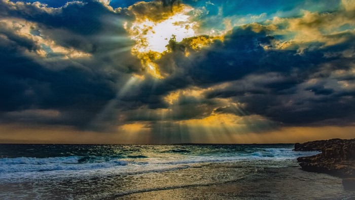 Sunbeams through clouds over the sea