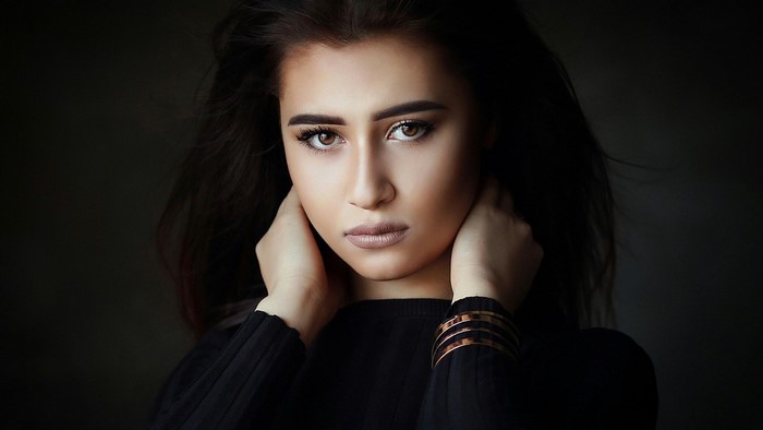 Woman with dark hair and bracelets