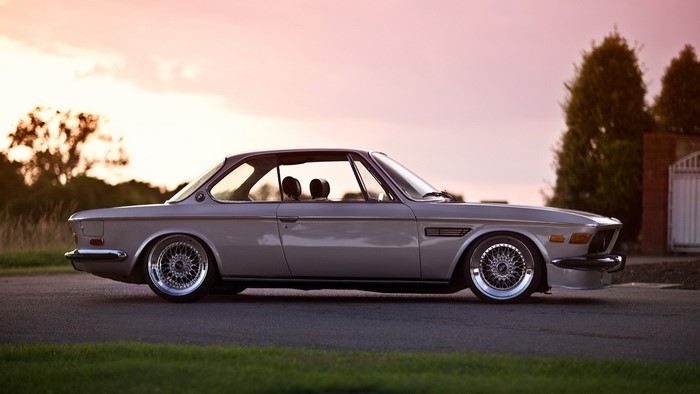 Retro BMW coupe on a road at sunset