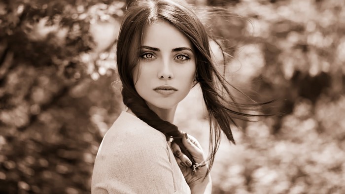 Sepia portrait of a young woman with braided hair