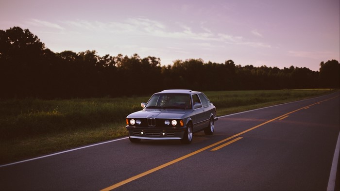 BMW car on a road at sunset