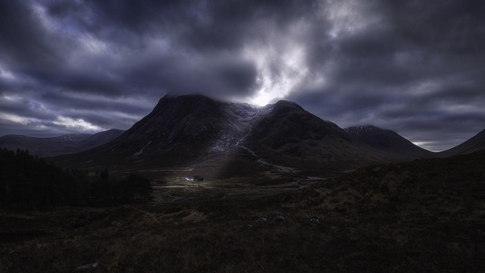 Dramatic mountain landscape in Scotland with a lone house