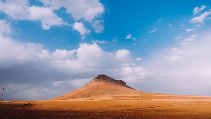 Mountain under a cloudy blue sky