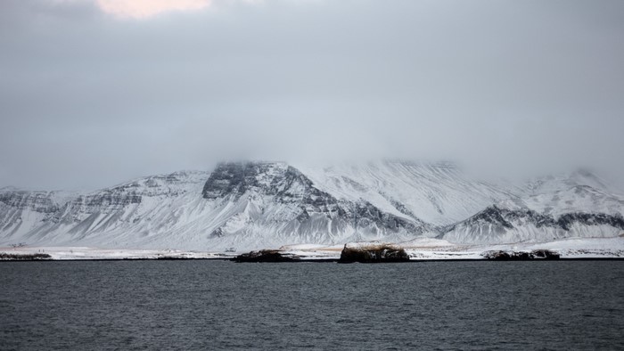 Snowy Mountains Overlooking Water in Iceland