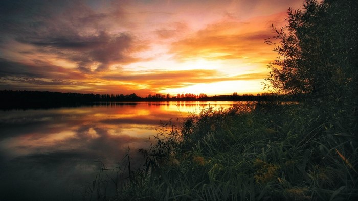 Sunset over a calm lake with reflections