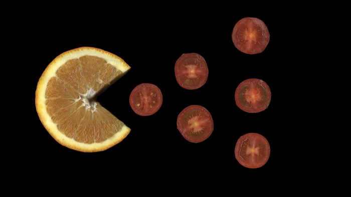 Orange slice and cherry tomatoes on black background