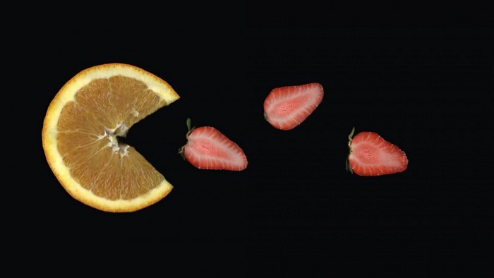 Orange slice and strawberries on black background