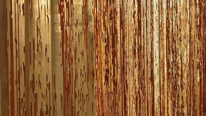 Corrugated metal texture with rust and light
