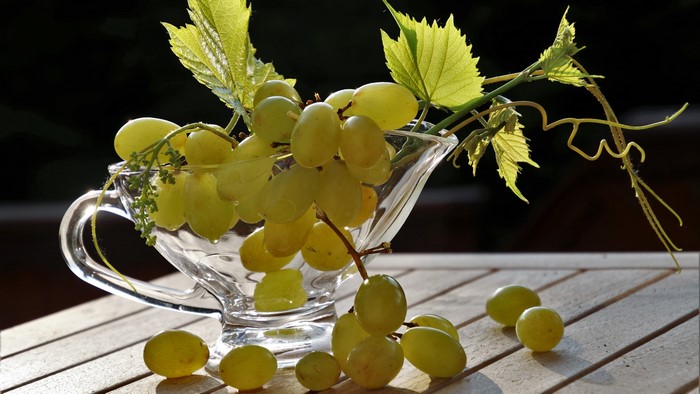 Still life of green grapes in a glass bowl