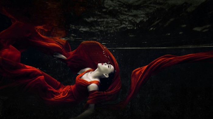 Woman in red dress underwater