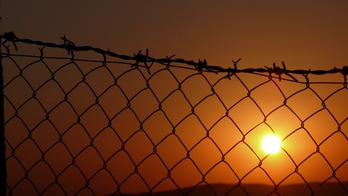 Sunset behind a barbed wire fence