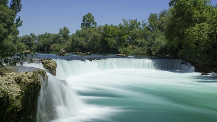 Waterfall with trees and blue sky
