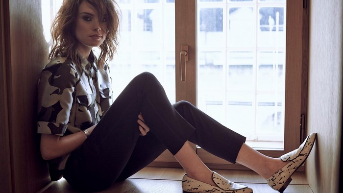 Daisy Ridley sitting by a window