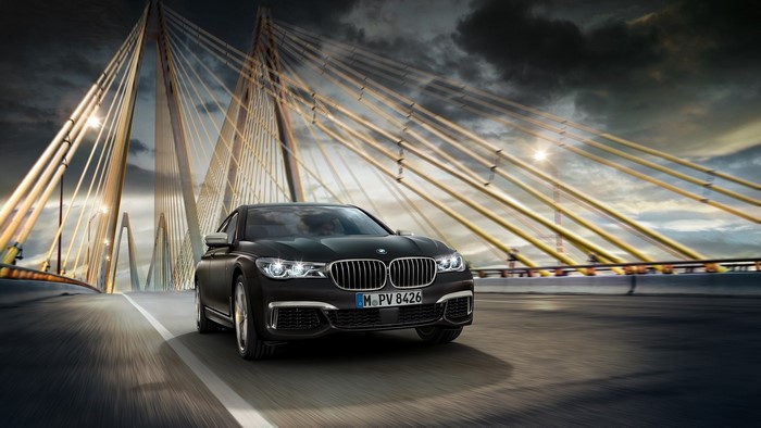Black BMW driving on a bridge
