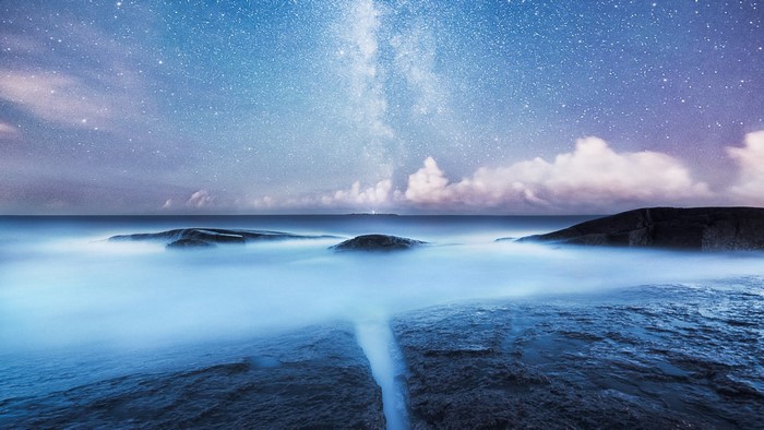 Milky Way over rocky coast at night