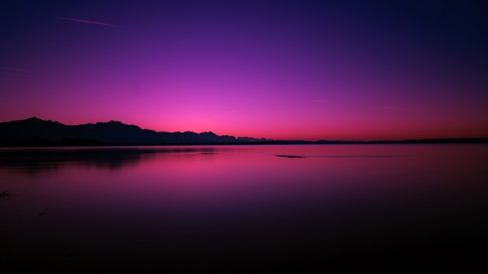Purple sunset over a lake with mountains