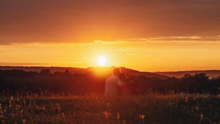 Couple watching sunset over hills