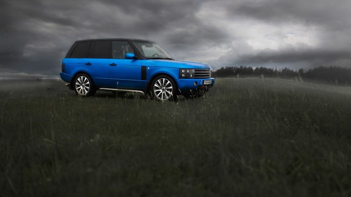 Blue Range Rover in a field
