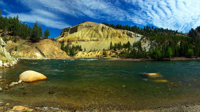Yellowstone River with colorful cliffs and pine trees