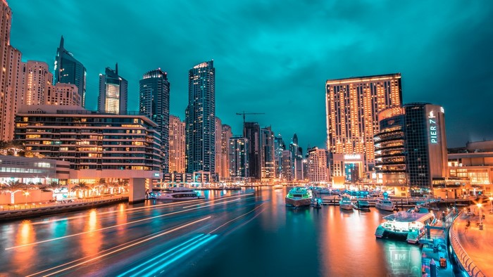 Night cityscape with illuminated skyscrapers and a canal