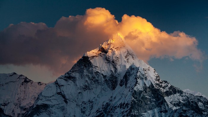 Snow-capped mountain peak with golden clouds