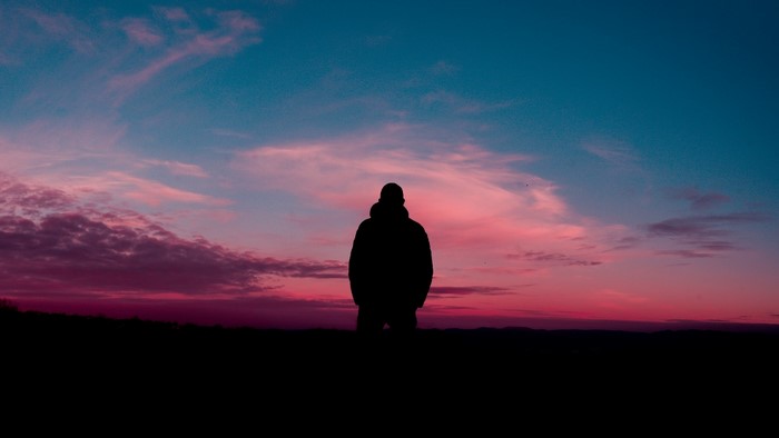 Silhouette of a person against a colorful sunset sky