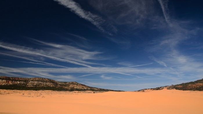 Coral Dunes Landscape with Mountains and Sky