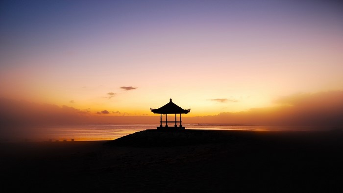 Silhouette of a gazebo on a beach at sunset