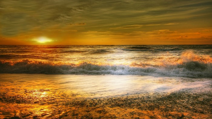 Sunset over the ocean with waves