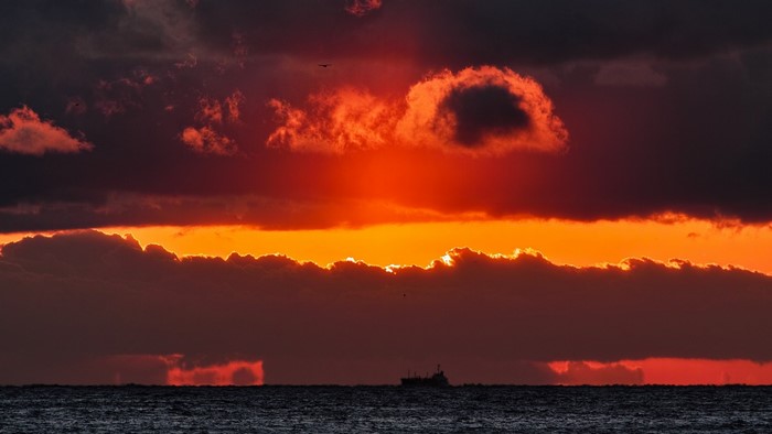 Dramatic sunset over the ocean with a ship