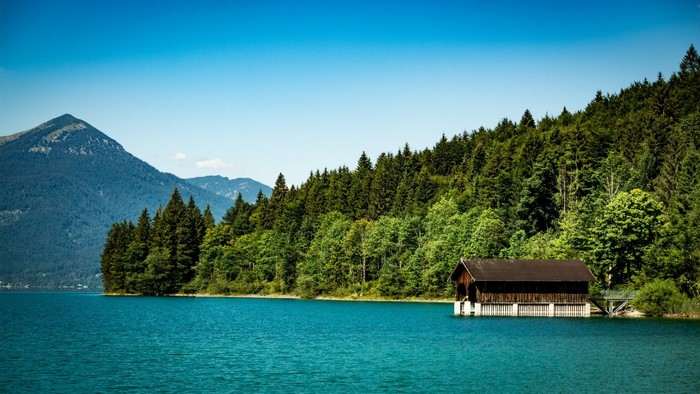 Boathouse on a lake with mountains and forest